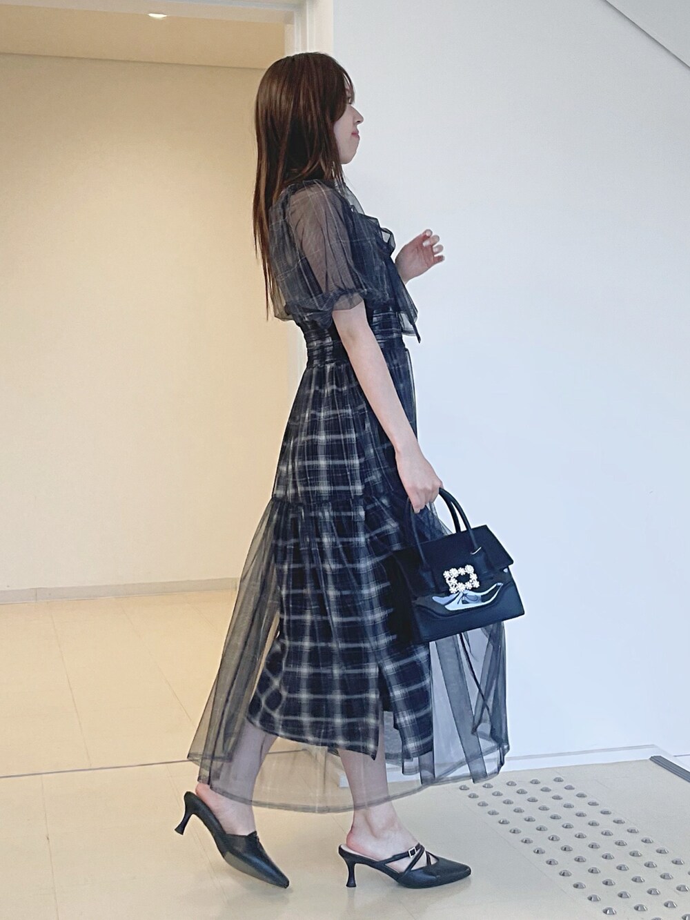 ブラック系のワンピース、ブラック系のショルダーバッグ、ブラック系のパンプスを着用したレディースの夏コーディネートの4枚目の写真