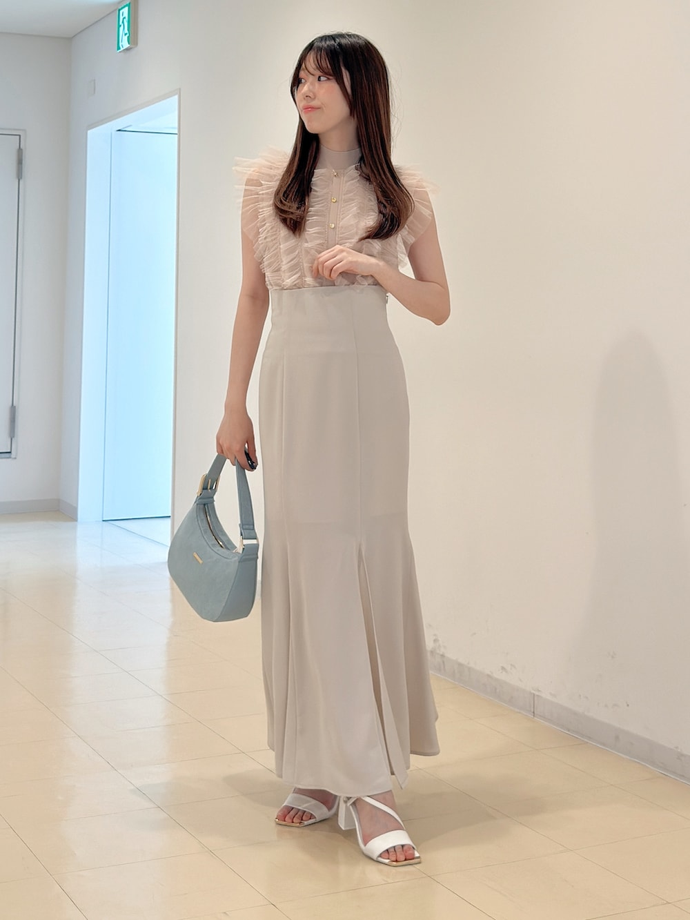 ピンク系のニット/セーター、ホワイト系のスカート、ブルー系のショルダーバッグを着用したレディースの春コーディネートの4枚目の写真