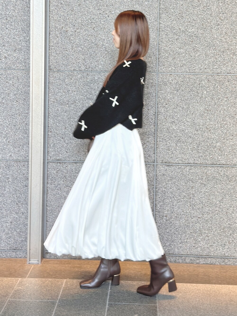 ブラック系のカーディガン/ボレロ、ホワイト系のスカート、ブラウン系のハンドバッグを着用したレディースの秋コーディネートの4枚目の写真