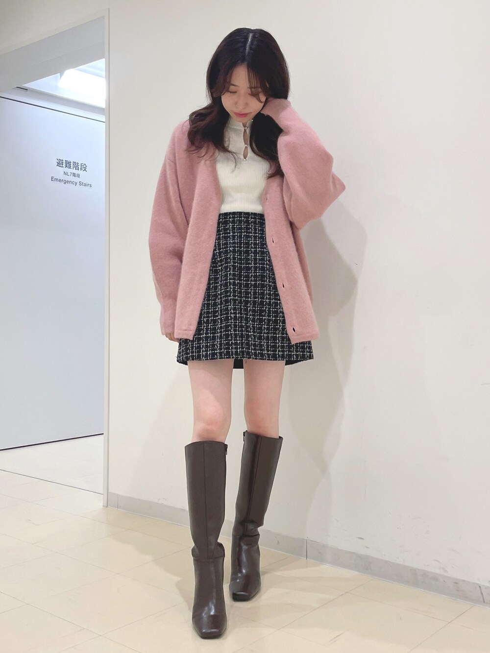 ブラック系のスカート、ホワイト系のニット/セーター、ピンク系のカーディガン/ボレロを着用したレディースの秋コーディネートの2枚目の写真