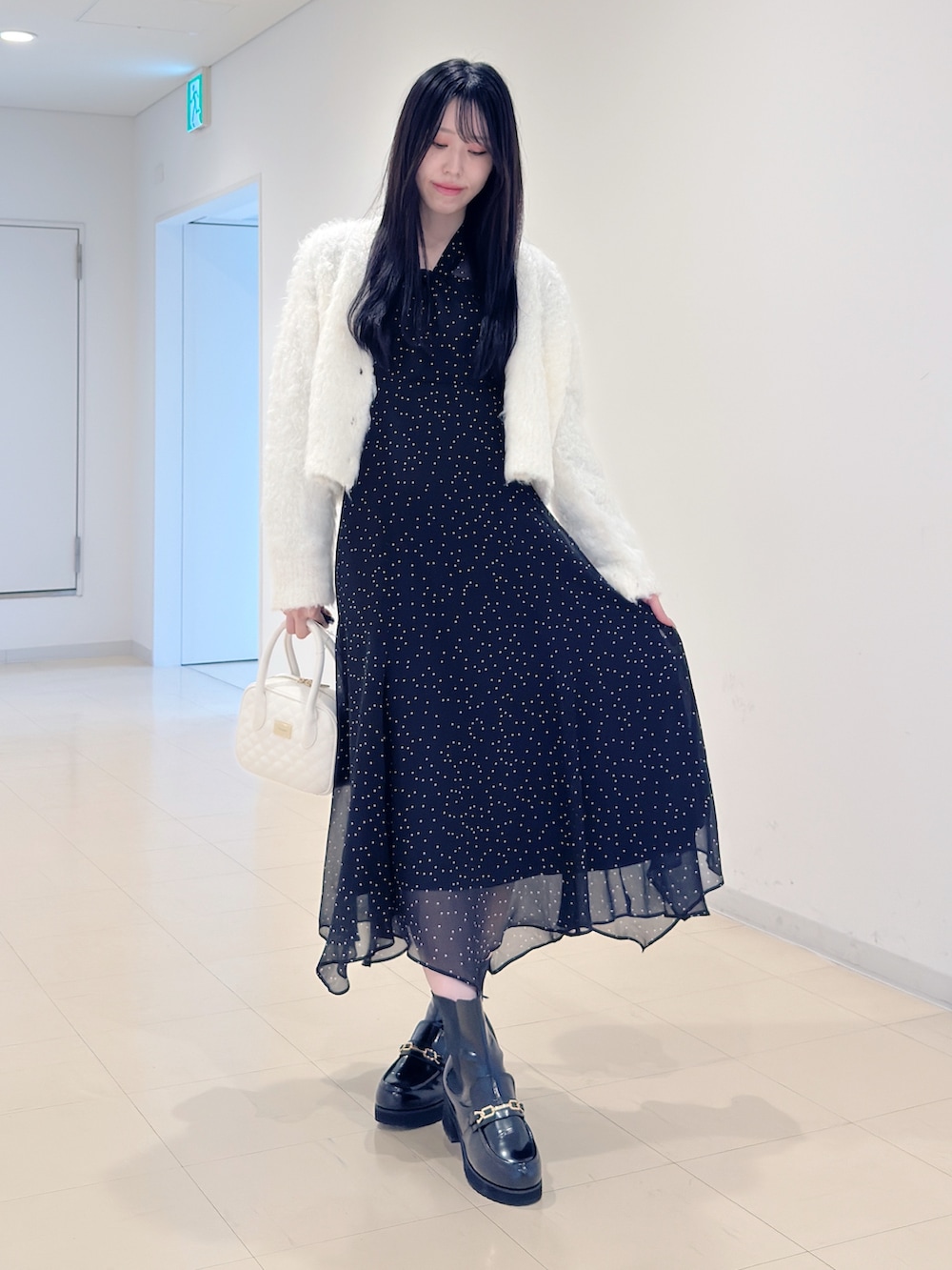 ホワイト系のカーディガン/ボレロ、その他のワンピース、ホワイト系のハンドバッグを着用したレディースの秋コーディネートの2枚目の写真