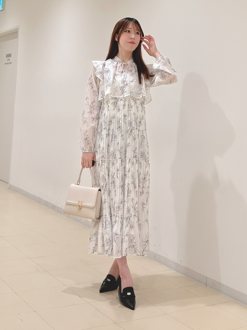 ホワイト系のワンピース、ホワイト系のハンドバッグ、ブラック系のパンプスを着用したレディースの春コーディネートの4枚目の写真