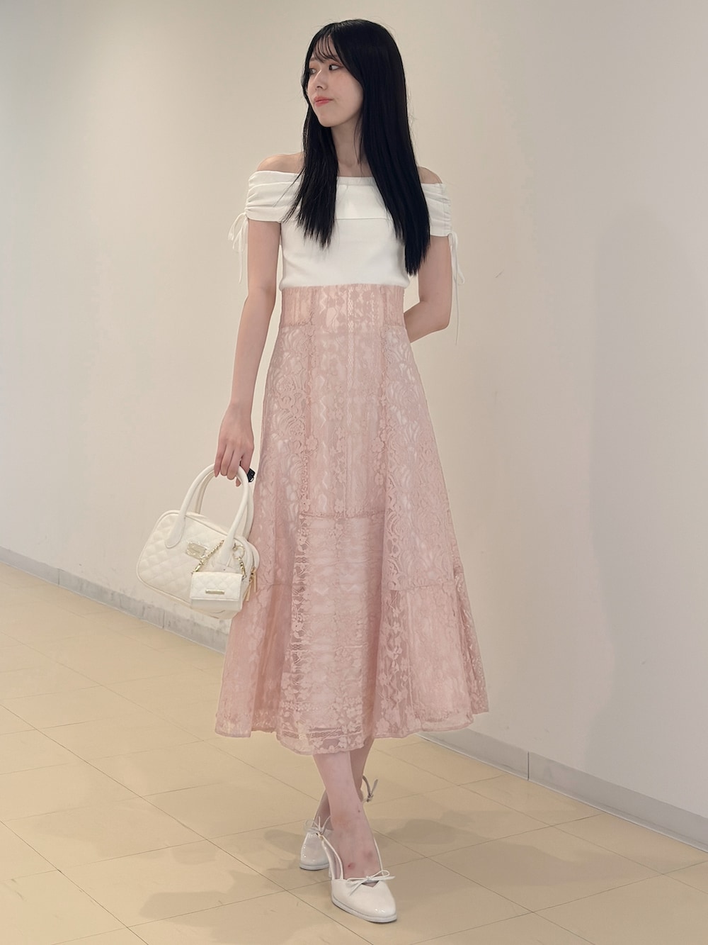 ホワイト系のニット/セーター、ブラック系のチューブトップ、ピンク系のスカートを着用したレディースの夏コーディネートの2枚目の写真