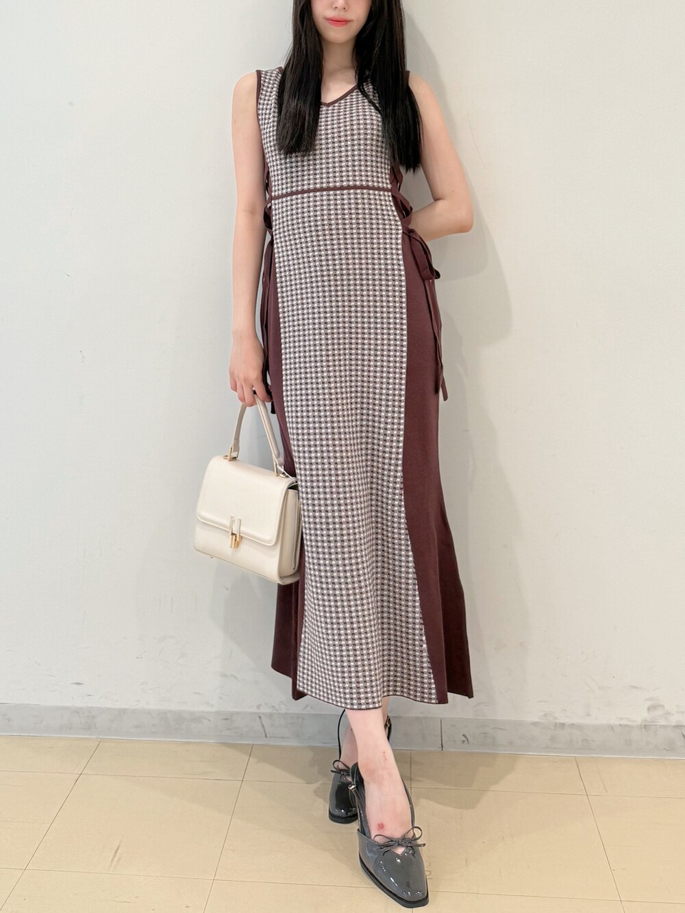ブラウン系のワンピース、ホワイト系のハンドバッグ、グレー系のパンプスを着用したレディースの夏コーディネートの3枚目の写真