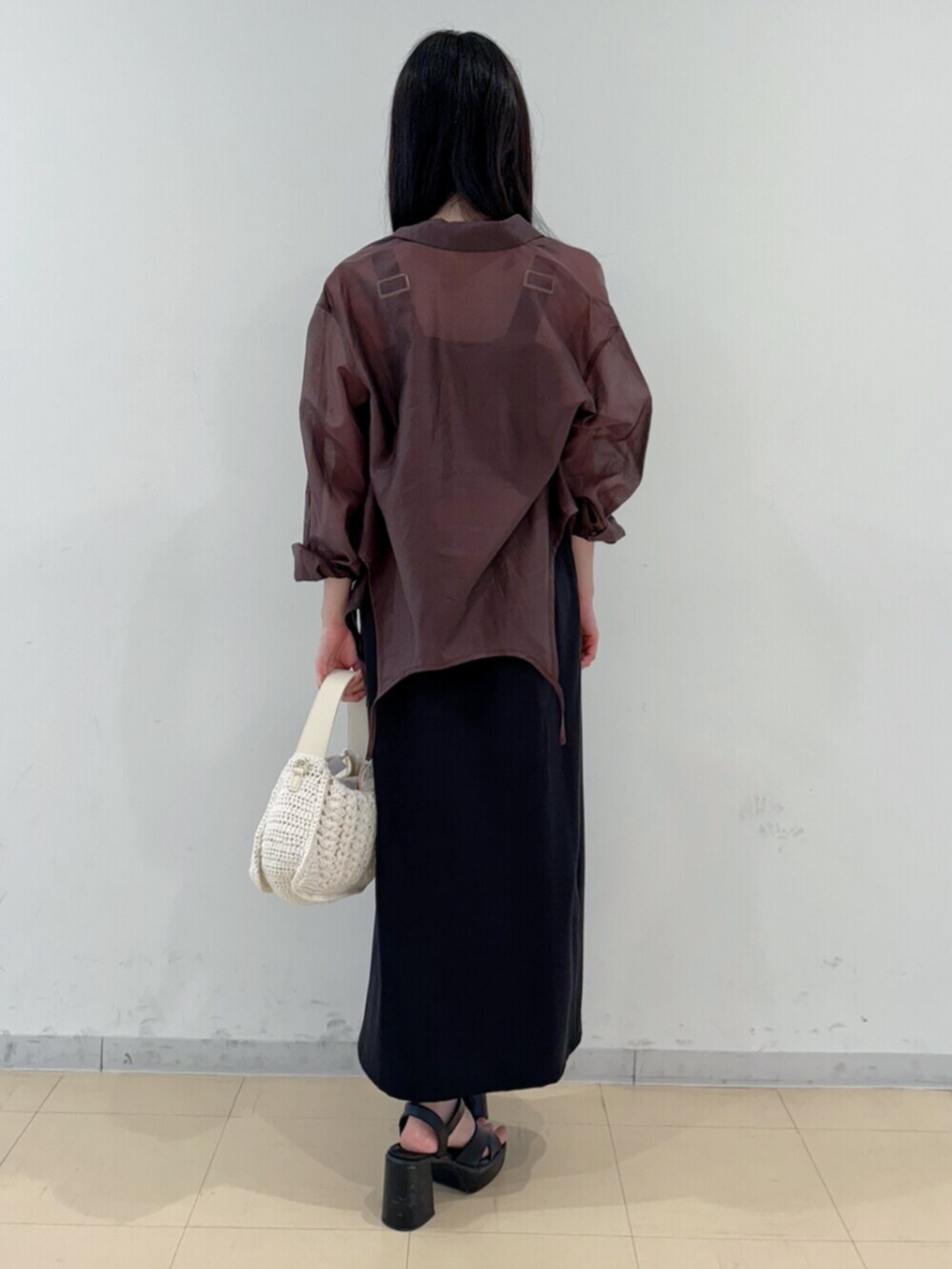 ブラック系のサンダル、ホワイト系のショルダーバッグ、ブラック系のワンピースを着用したレディースの夏コーディネートの4枚目の写真