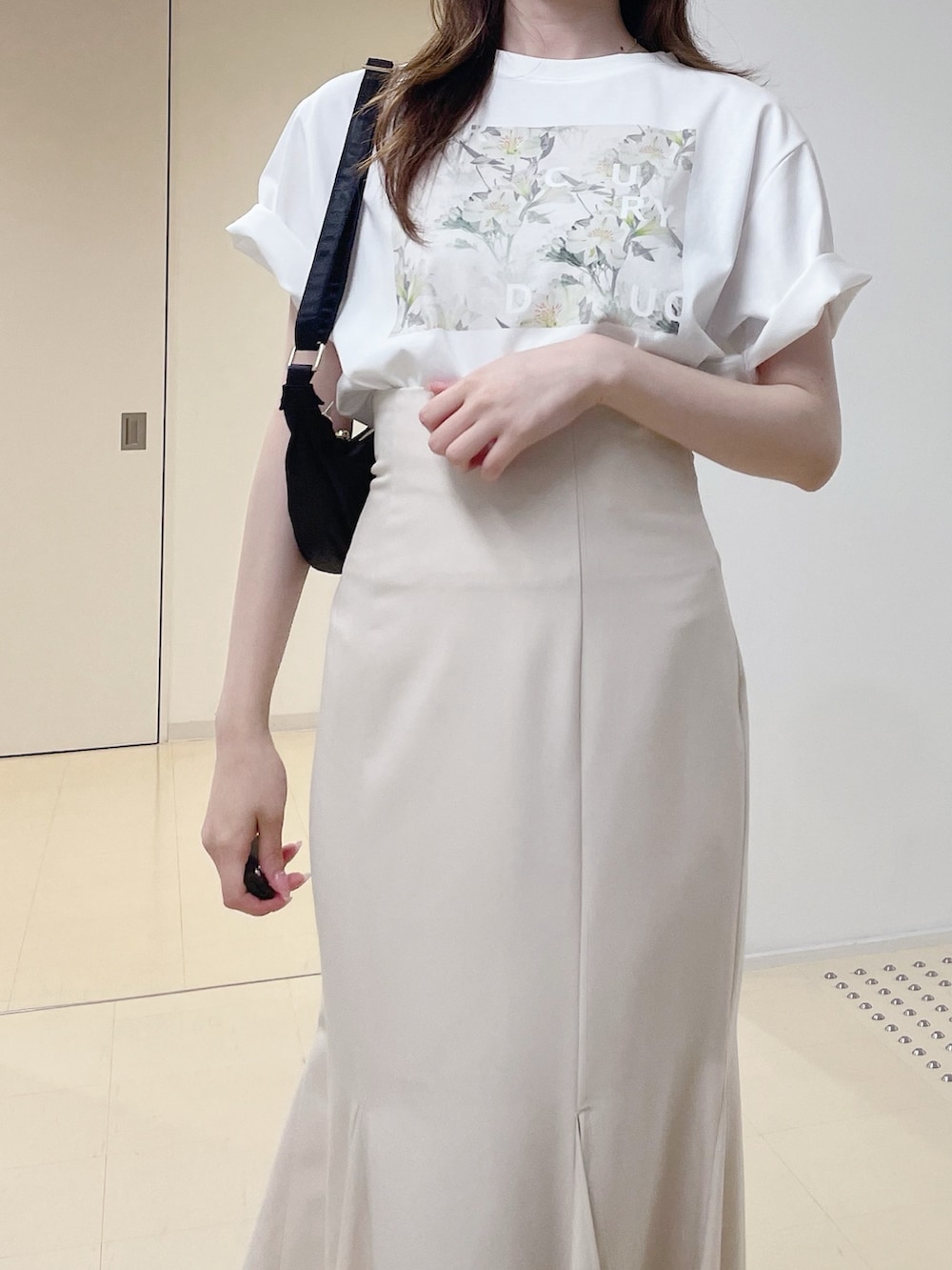 ホワイト系のTシャツ/カットソー、ホワイト系のスカート、ブラック系のショルダーバッグを着用したレディースの夏コーディネートの6枚目の写真