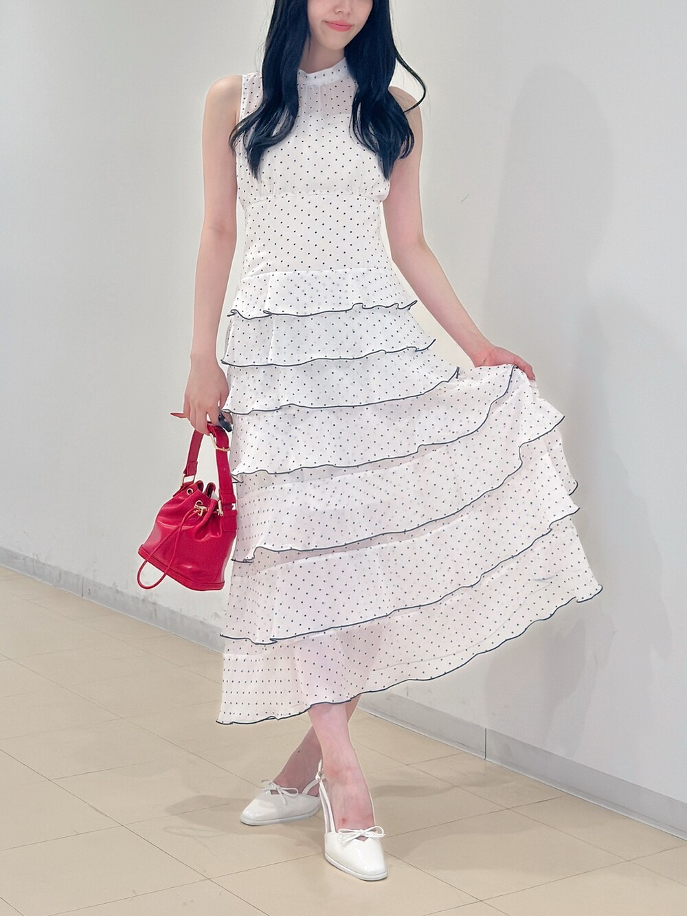 その他のワンピース、レッド系のハンドバッグ、ホワイト系のパンプスを着用したレディースの夏コーディネートの3枚目の写真