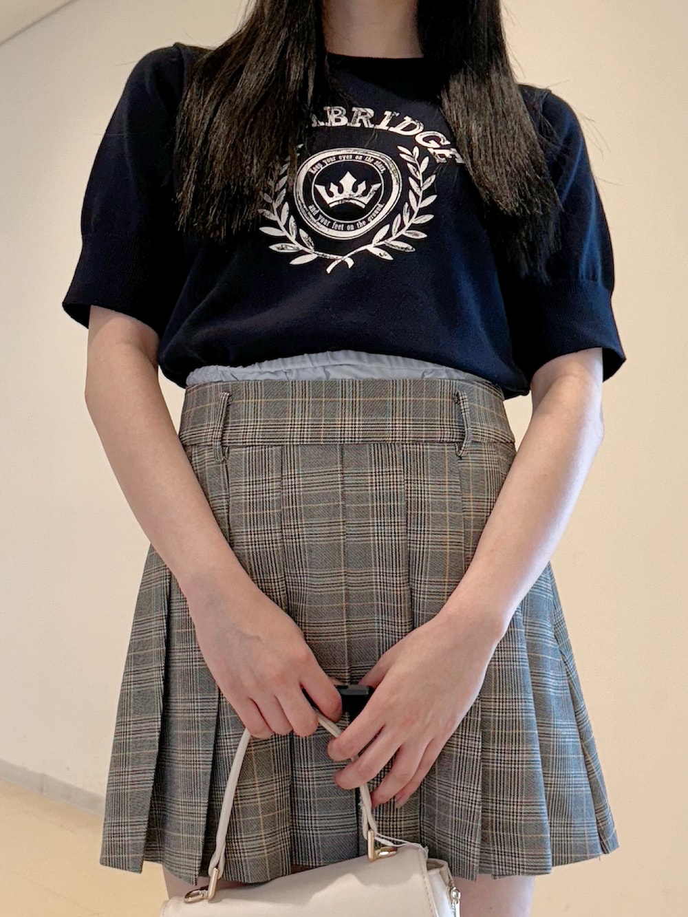 ブルー系のニット/セーター、グレー系のスカート、ホワイト系のハンドバッグを着用したレディースの夏コーディネートの6枚目の写真