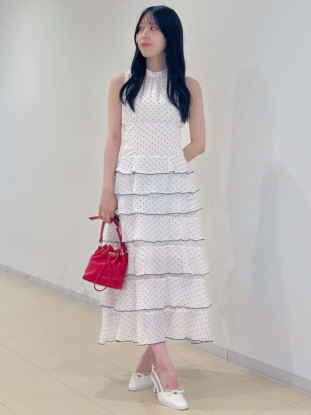 その他のワンピース、レッド系のハンドバッグ、ホワイト系のパンプスを着用したレディースの夏コーディネートの2枚目の写真