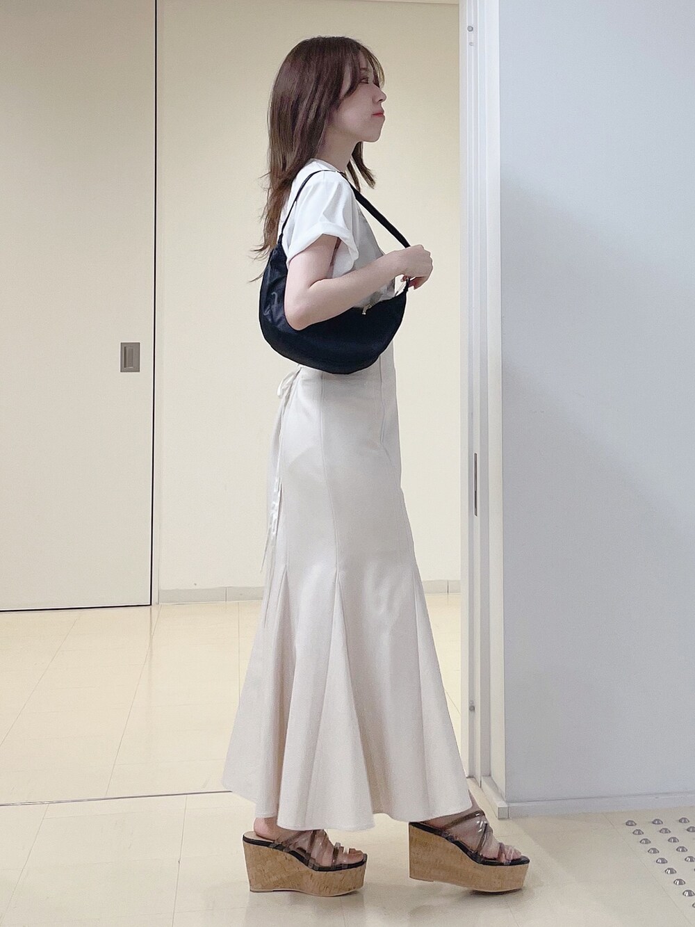 ホワイト系のTシャツ/カットソー、ホワイト系のスカート、ブラック系のショルダーバッグを着用したレディースの夏コーディネートの3枚目の写真