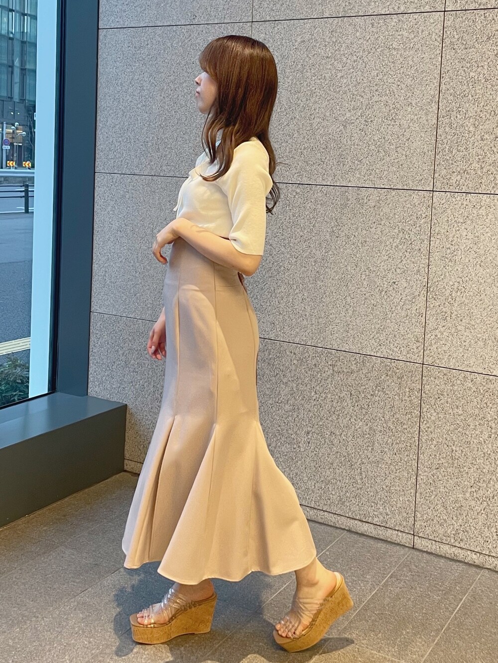 ピンク系のスカート、ホワイト系のサンダル、ホワイト系のニット/セーターを着用したレディースの春コーディネートの2枚目の写真