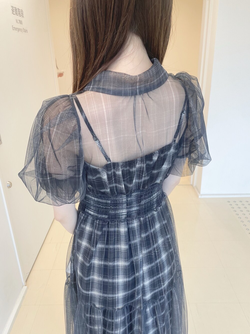 ブラック系のワンピース、ブラック系のショルダーバッグ、ブラック系のパンプスを着用したレディースの夏コーディネートの6枚目の写真