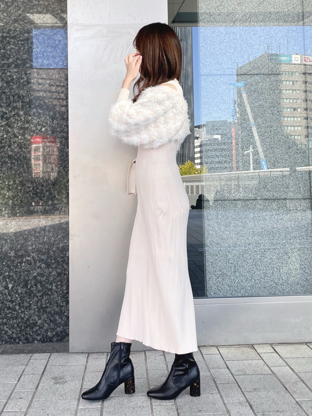 ベージュ系のワンピース、ホワイト系のショルダーバッグ、ブラック系のブーツを着用したレディースの冬コーディネートの4枚目の写真