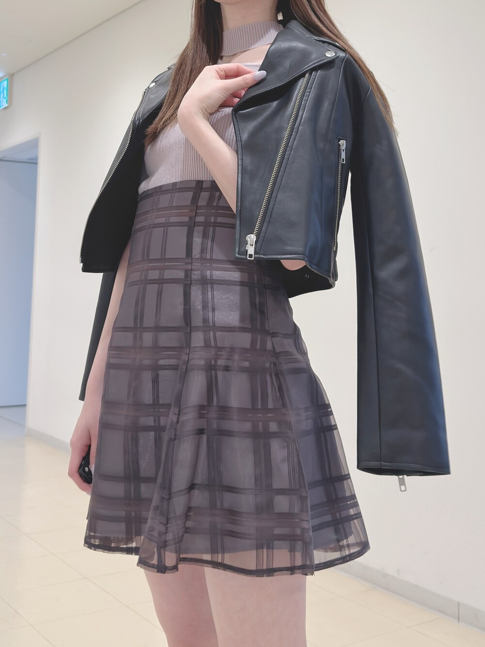 ブラック系のライダースジャケット、ベージュ系のニット/セーター、ブラウン系のその他パンツを着用したレディースの春コーディネートの6枚目の写真