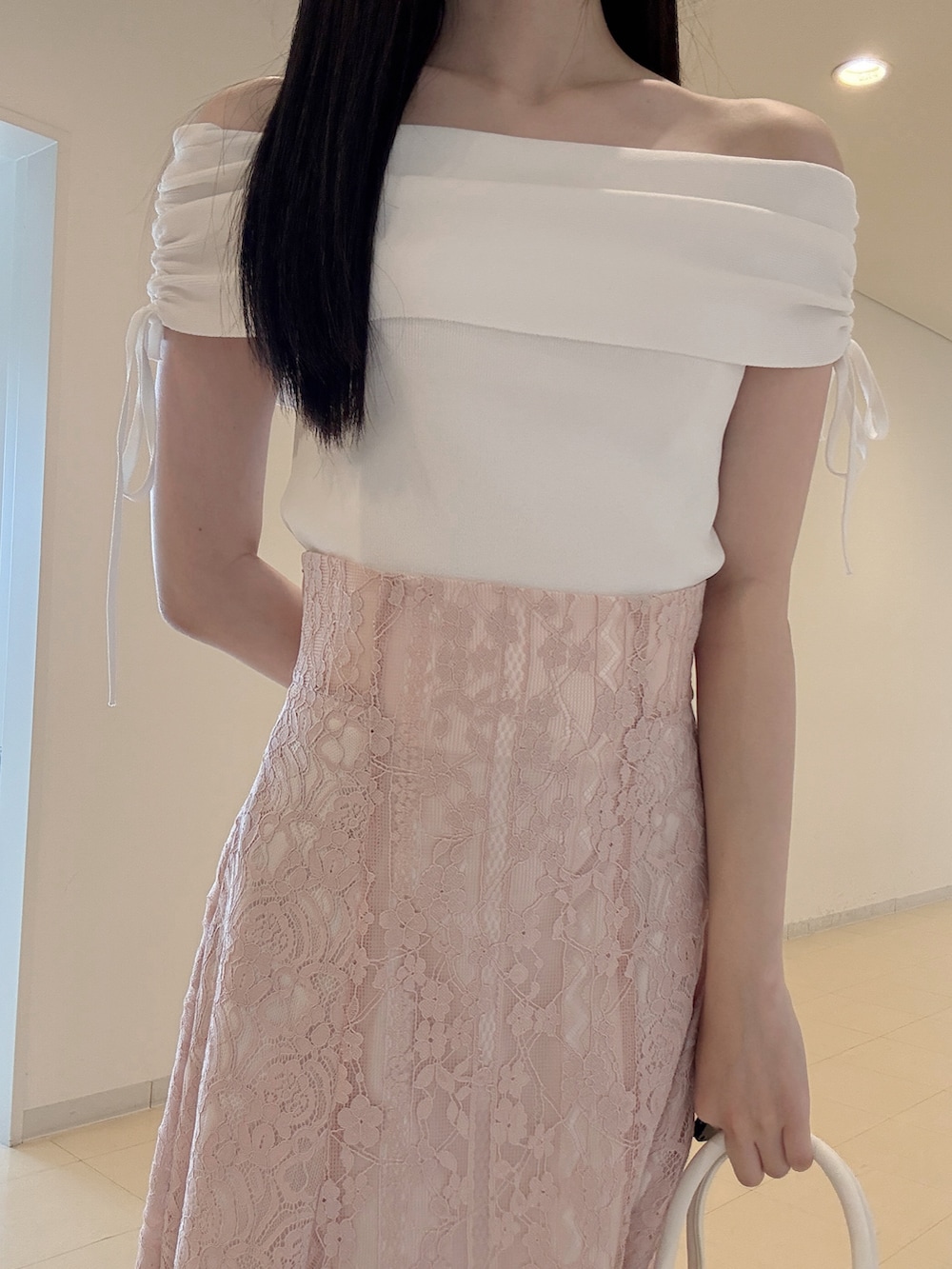 ホワイト系のニット/セーター、ブラック系のチューブトップ、ピンク系のスカートを着用したレディースの夏コーディネートの5枚目の写真