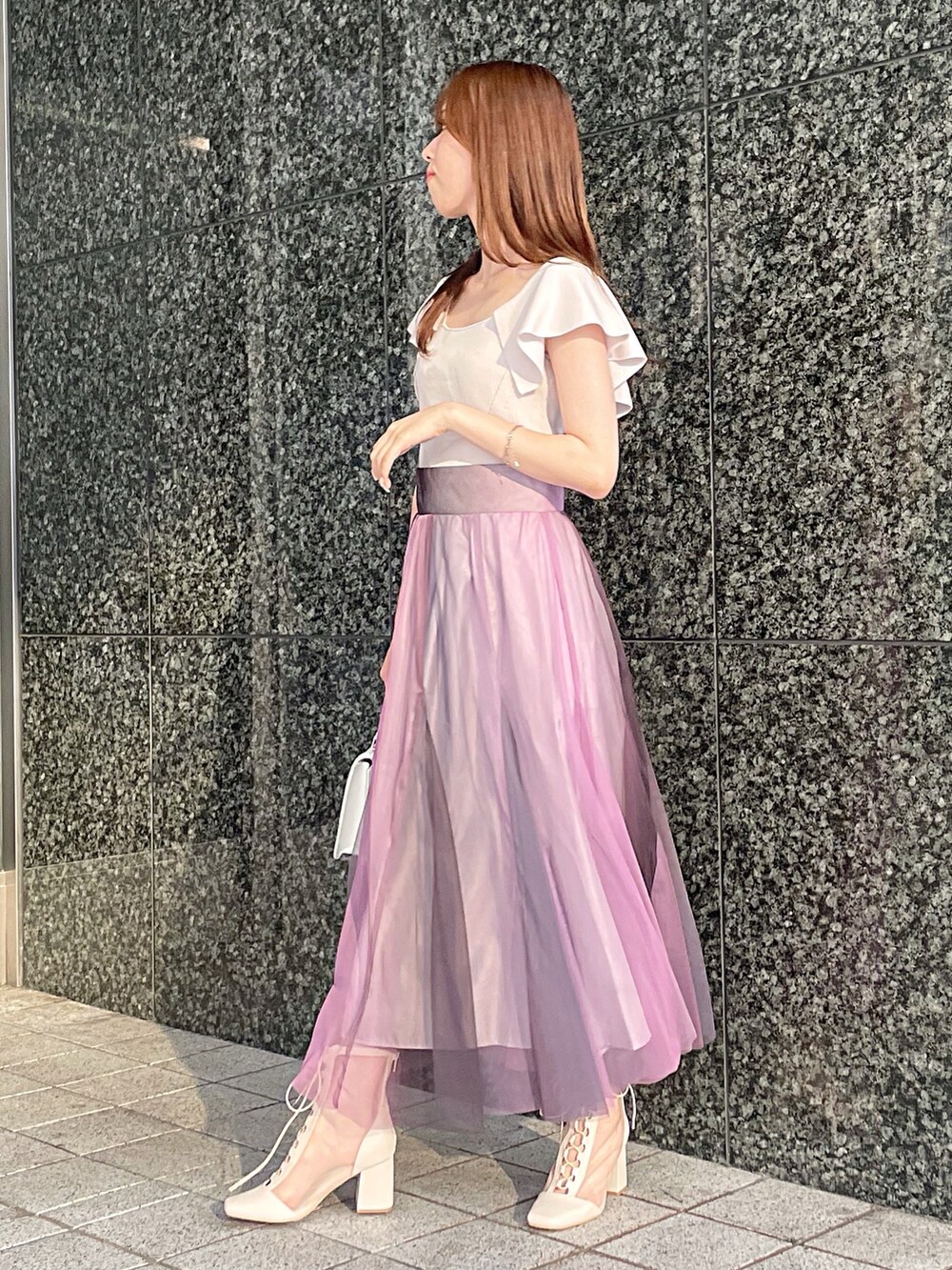 ピンク系のニット/セーター、ホワイト系のハンドバッグ、ホワイト系のブーツを着用したレディースの夏コーディネートの4枚目の写真