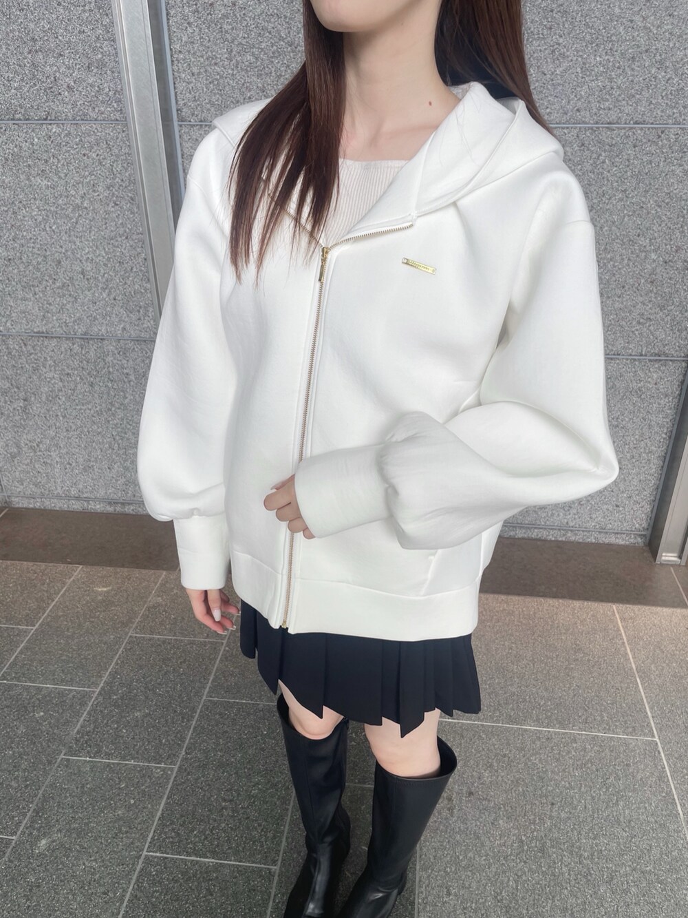 ホワイト系のパーカー、ブラック系のその他パンツ、ブラック系のブーツを着用したレディースの秋コーディネートの7枚目の写真