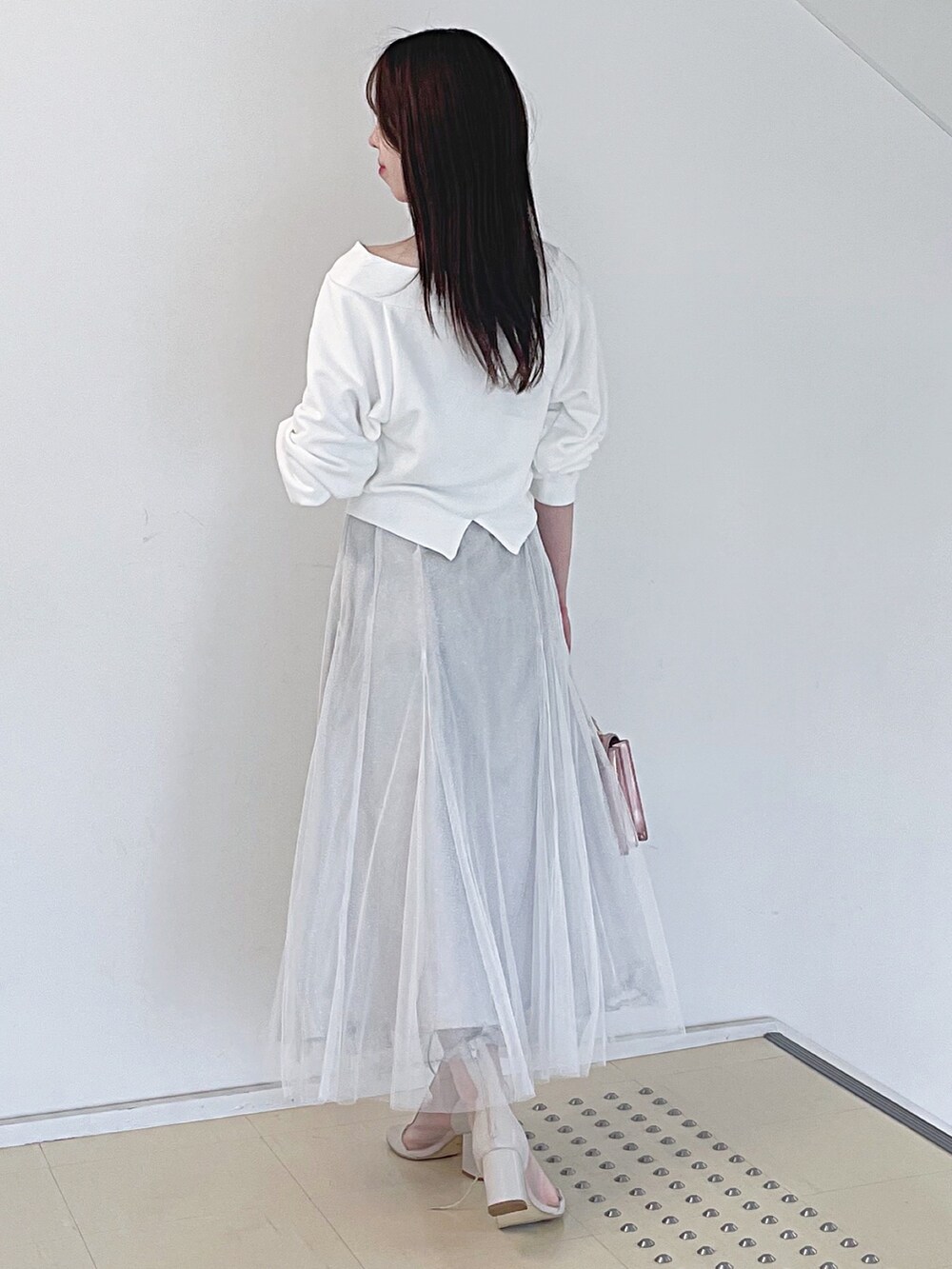 ホワイト系のスウェット、ホワイト系のスカート、ピンク系のハンドバッグを着用したレディースの秋コーディネートの5枚目の写真