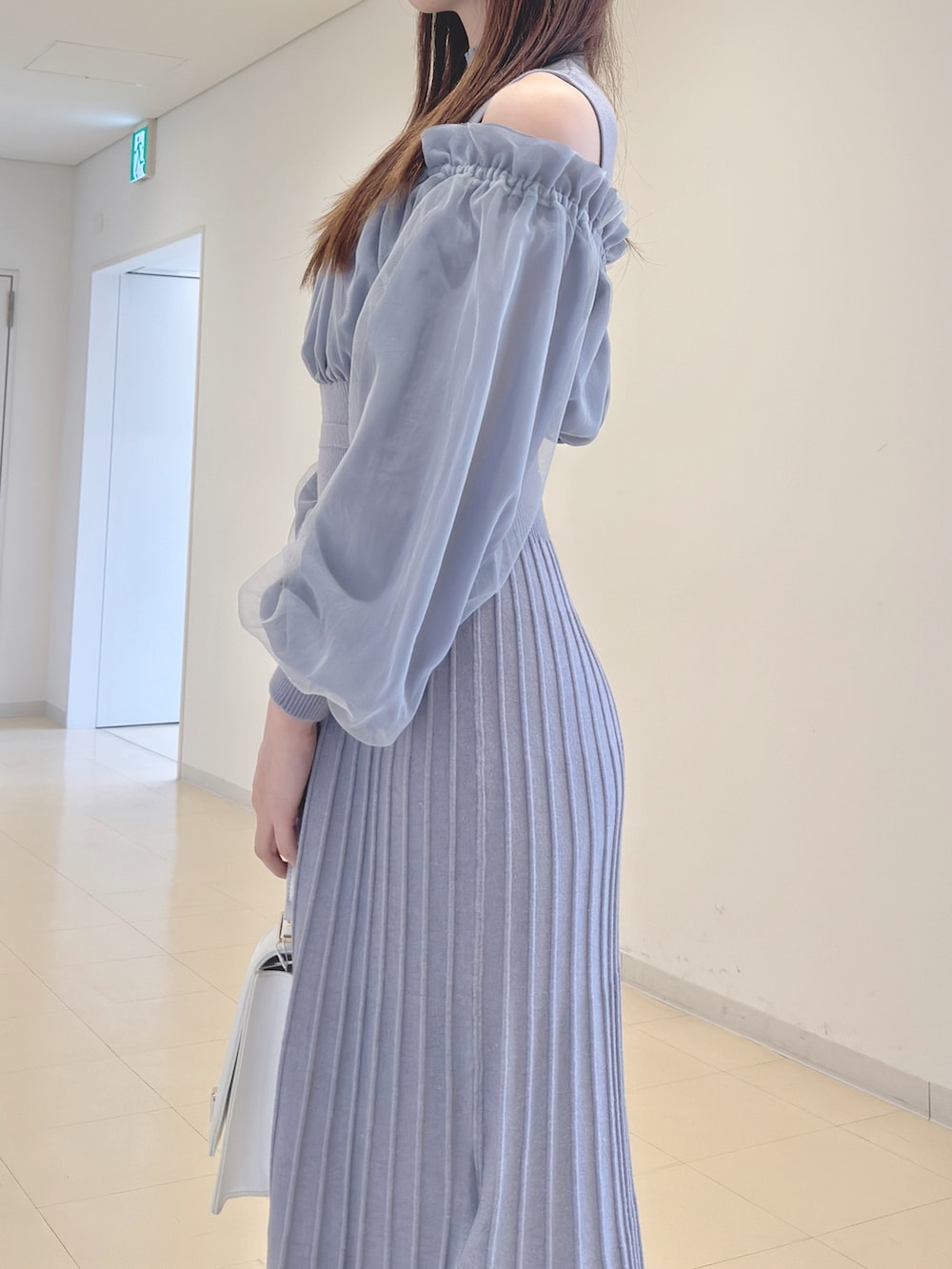 ブルー系のワンピース、ホワイト系のハンドバッグ、ホワイト系のパンプスを着用したレディースの冬コーディネートの6枚目の写真