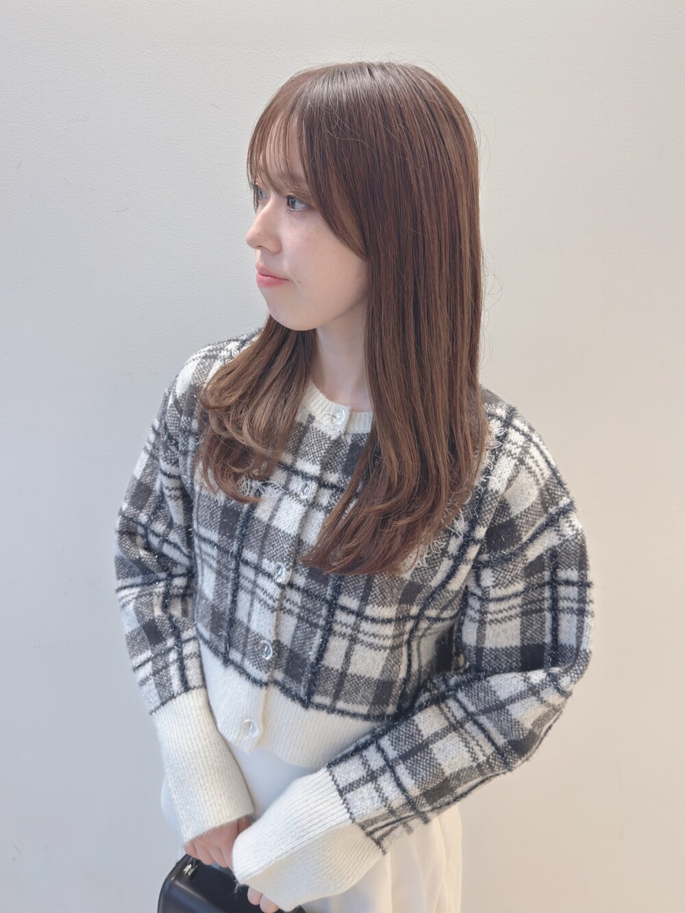 ホワイト系のカーディガン/ボレロ、ブラウン系のハンドバッグ、ホワイト系のスカートを着用したレディースの秋コーディネートの6枚目の写真