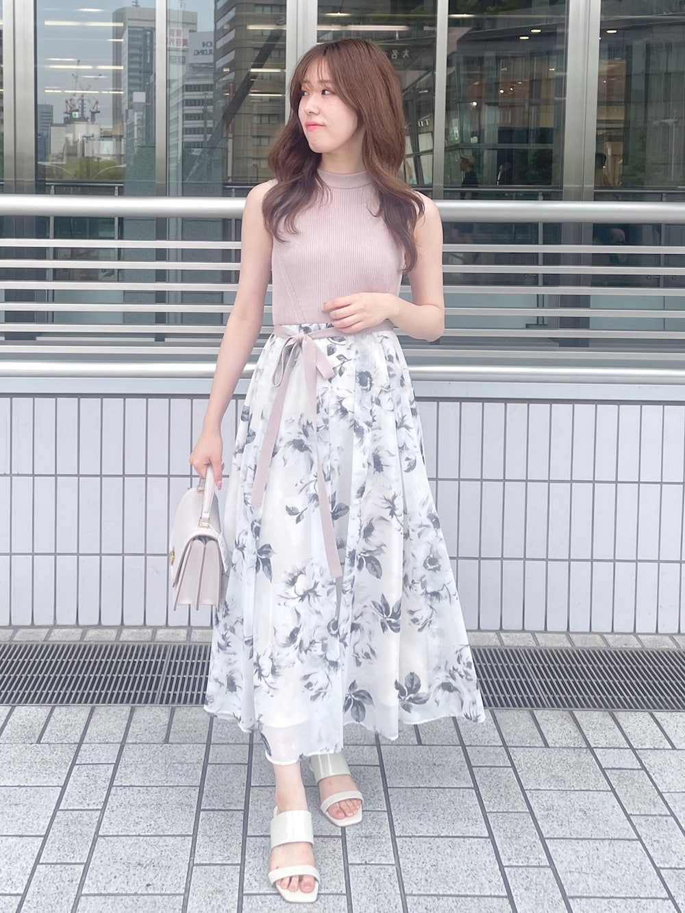 ベージュ系のワンピース、ピンク系のハンドバッグ、ホワイト系のサンダルを着用したレディースの夏コーディネートの2枚目の写真