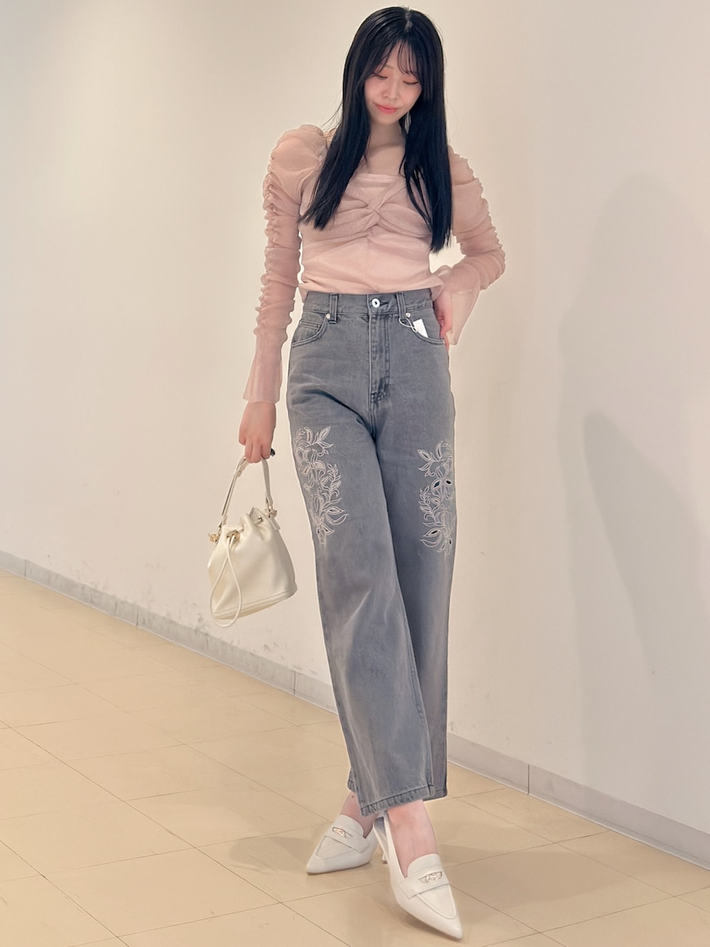 グレー系のデニムパンツ、ホワイト系のハンドバッグ、ピンク系のTシャツ/カットソーを着用したレディースの夏コーディネートの2枚目の写真