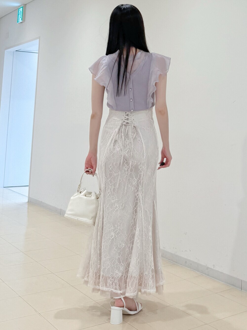 ホワイト系のスカート、ホワイト系のサンダル、ホワイト系のハンドバッグを着用したレディースの春コーディネートの5枚目の写真