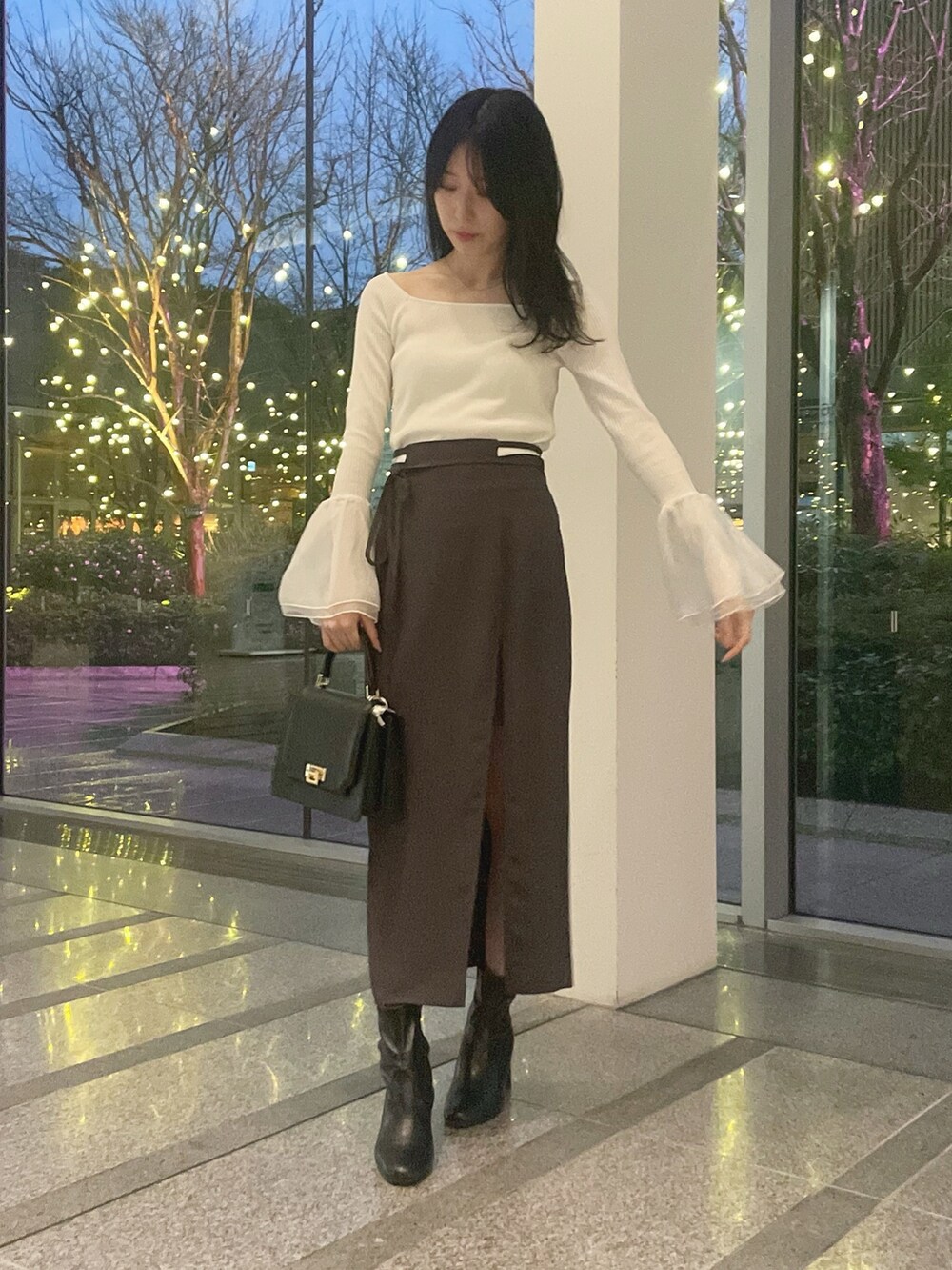 ホワイト系のテーラードジャケット、ホワイト系のニット/セーター、グレー系のスカートを着用したレディースの冬コーディネートの5枚目の写真