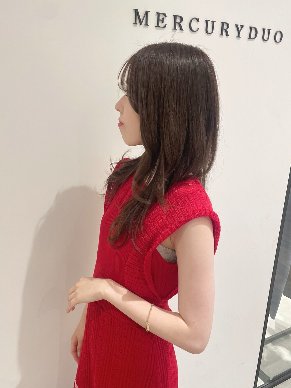 レッド系のワンピース、ブラック系のハンドバッグ、その他のサンダルを着用したレディースの春コーディネートの9枚目の写真