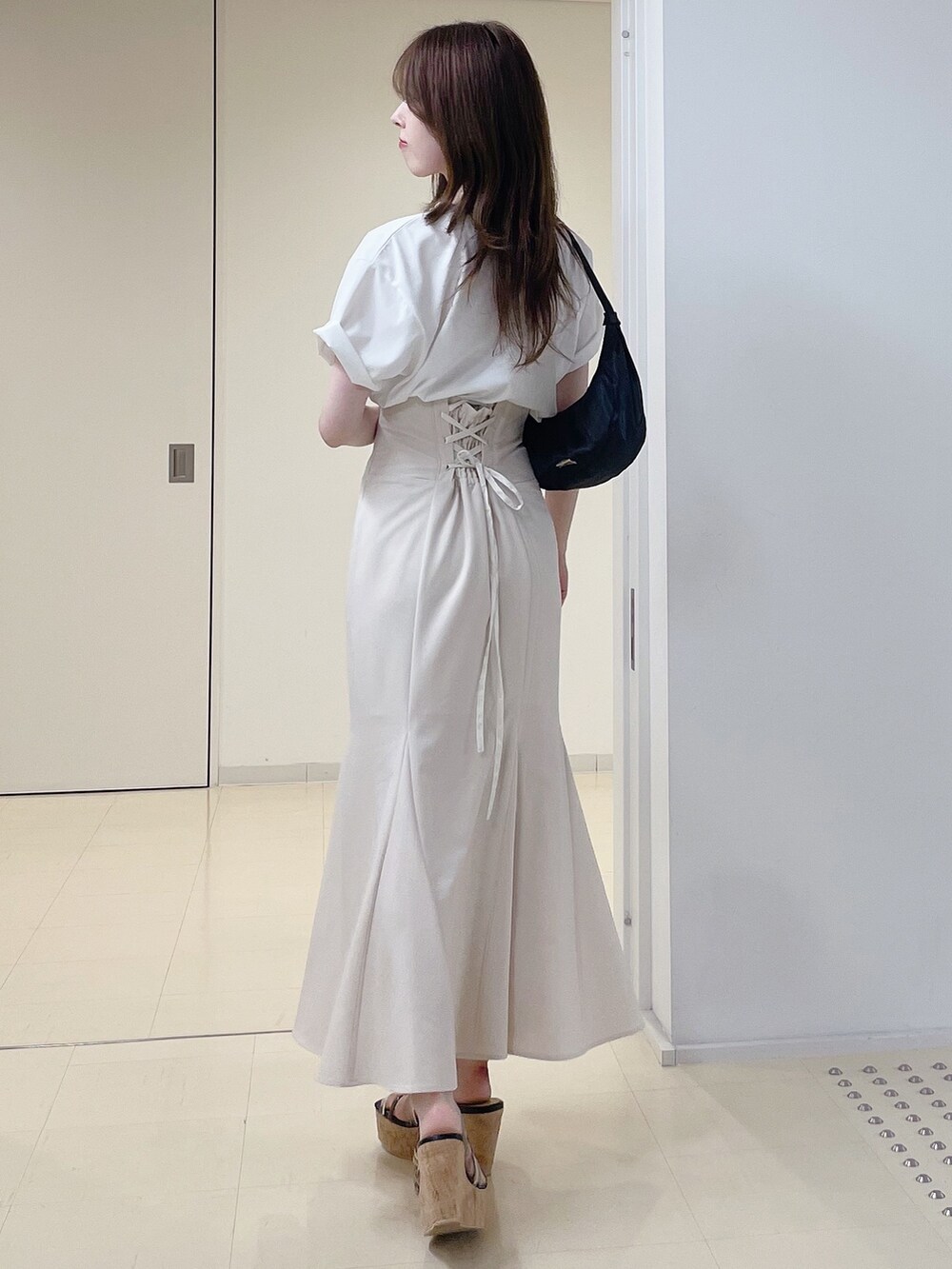 ホワイト系のTシャツ/カットソー、ホワイト系のスカート、ブラック系のショルダーバッグを着用したレディースの夏コーディネートの4枚目の写真