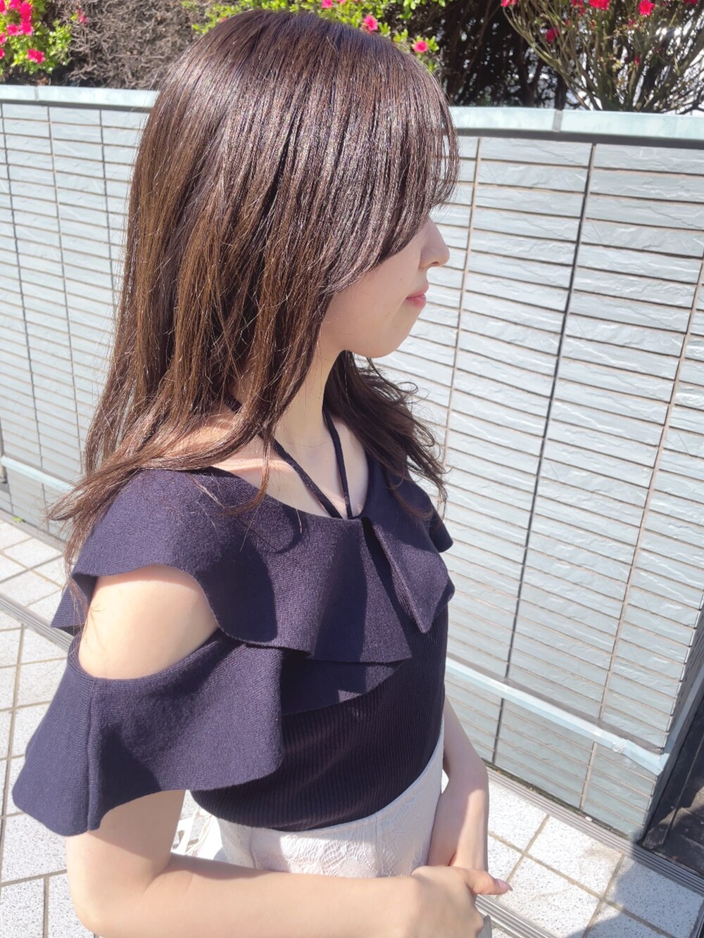 ブルー系のニット/セーター、ホワイト系のスカート、ホワイト系のハンドバッグを着用したレディースの春コーディネートの8枚目の写真