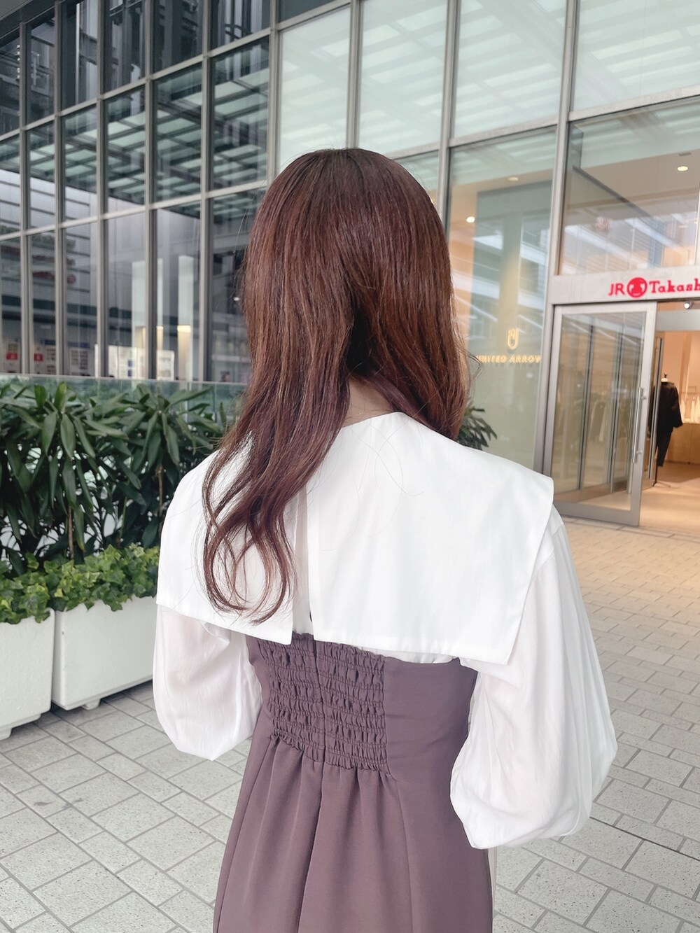 パープル系のワンピース、ブラック系のブーツを着用したレディースの冬コーディネートの5枚目の写真