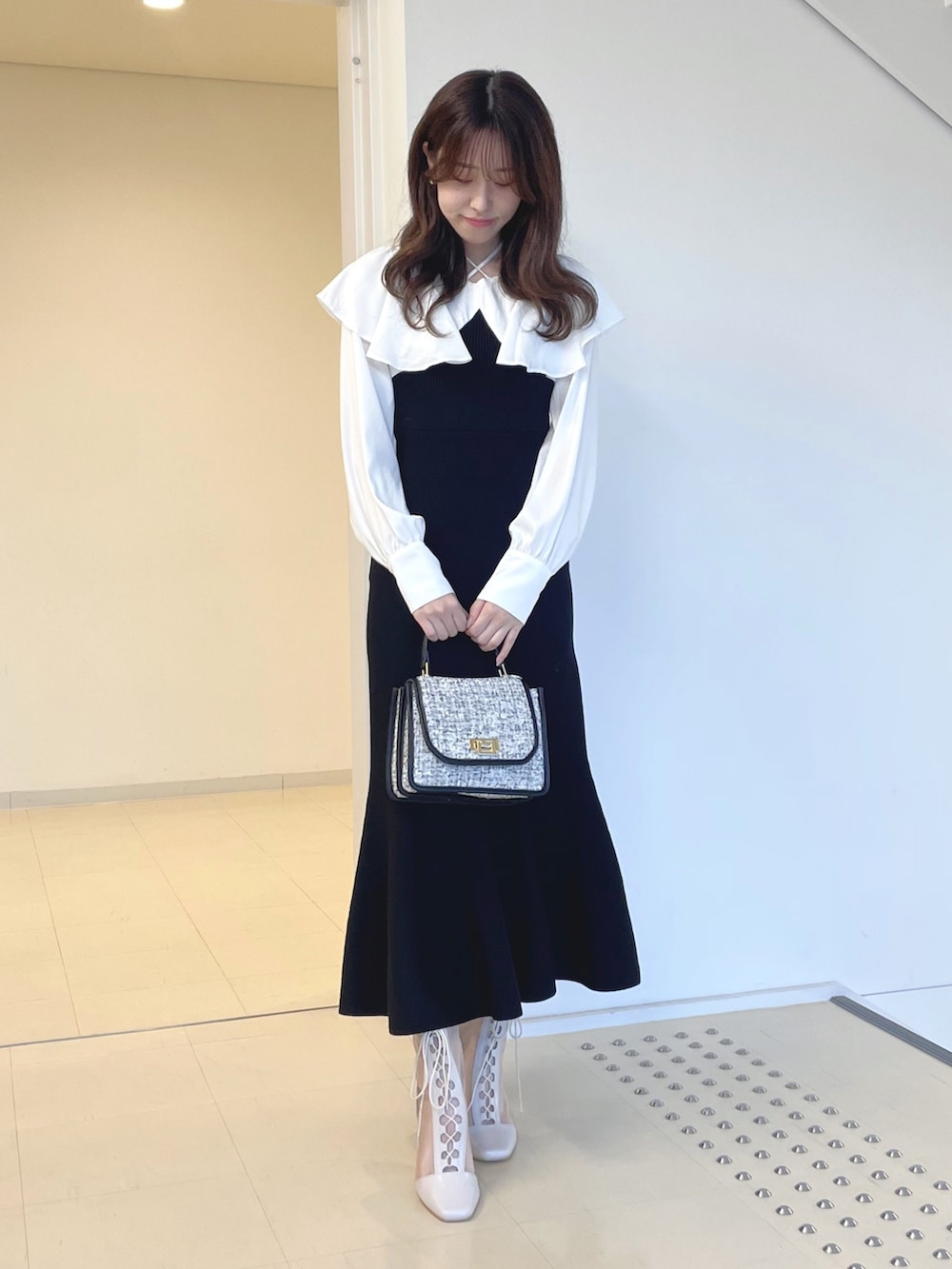 ホワイト系のブーツ、ブラック系のショルダーバッグ、ブラック系のワンピースを着用したレディースの秋コーディネートの2枚目の写真