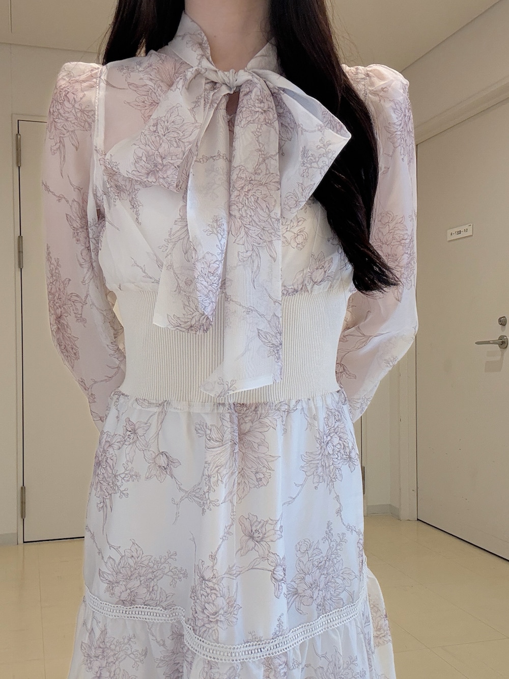 ベージュ系のワンピース、ホワイト系のショルダーバッグ、ブラウン系のパンプスを着用したレディースの冬コーディネートの6枚目の写真