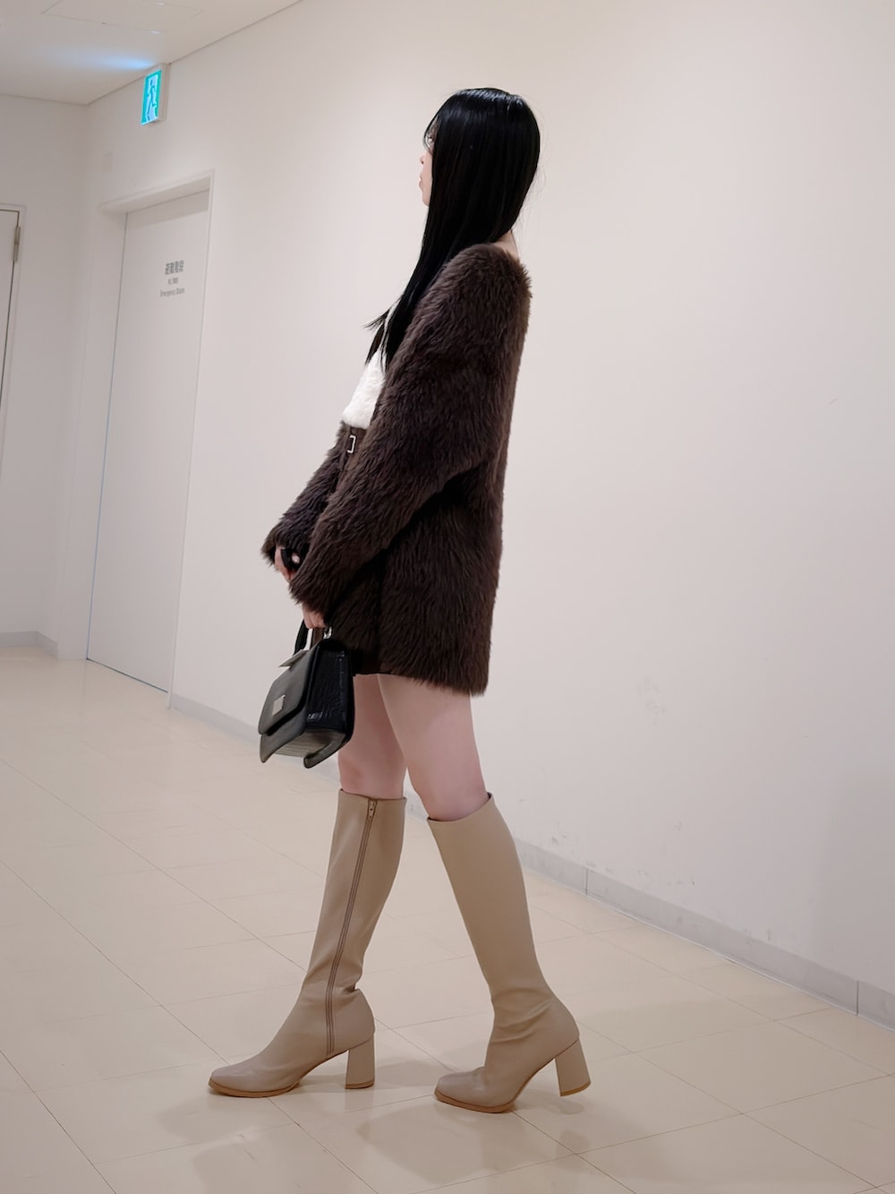 ブラウン系のカーディガン/ボレロ、ホワイト系のニット/セーター、ブラウン系のスカートを着用したレディースの秋コーディネートの3枚目の写真