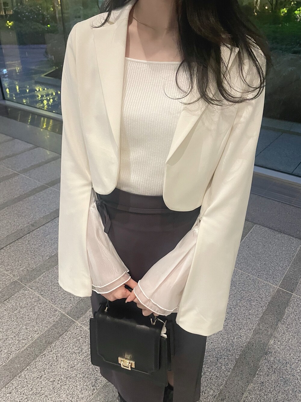 ホワイト系のテーラードジャケット、ホワイト系のニット/セーター、グレー系のスカートを着用したレディースの冬コーディネートの8枚目の写真