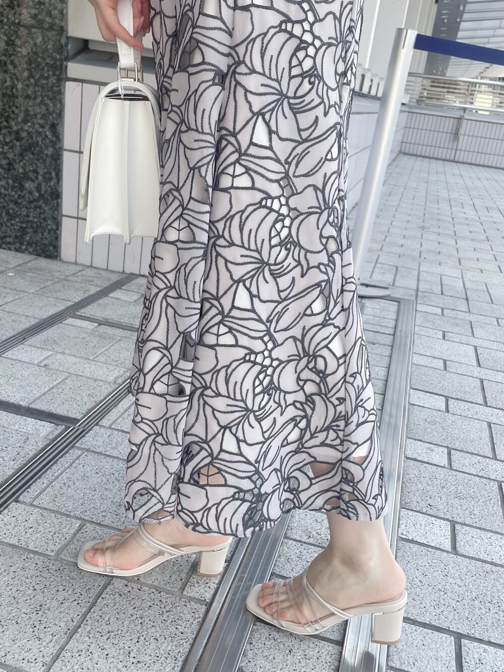 ベージュ系のワンピース、ホワイト系のハンドバッグ、その他のサンダルを着用したレディースの夏コーディネートの8枚目の写真