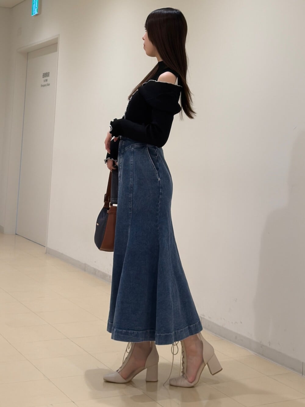 ホワイト系のブーツ、ブルー系のショルダーバッグ、ブラック系のニット/セーターを着用したレディースの春コーディネートの4枚目の写真