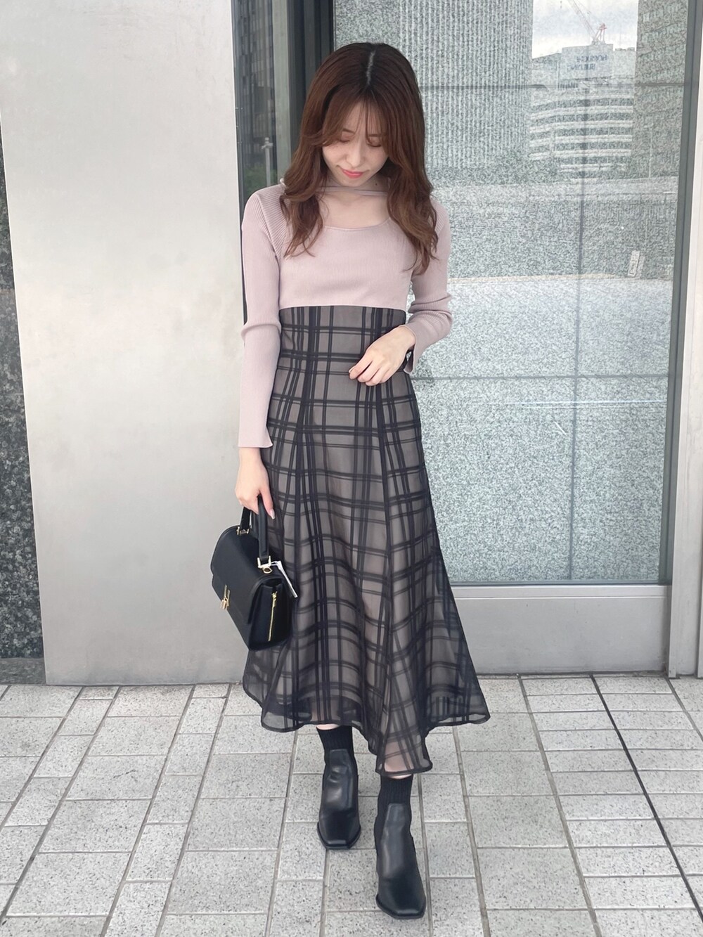 ピンク系のワンピース、ブラック系のショルダーバッグ、ブラック系のブーツを着用したレディースの秋コーディネートの3枚目の写真
