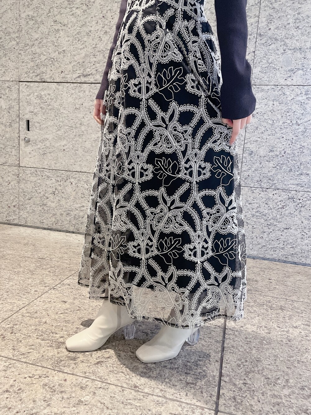 ブラウン系のニット/セーター、ブラック系のスカート、ホワイト系のブーツを着用したレディースの冬コーディネートの4枚目の写真