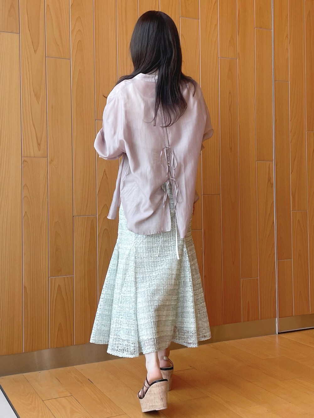 ベージュ系のシャツ/ブラウス、ホワイト系のニット/セーター、グリーン系のスカートを着用したレディースの春コーディネートの3枚目の写真