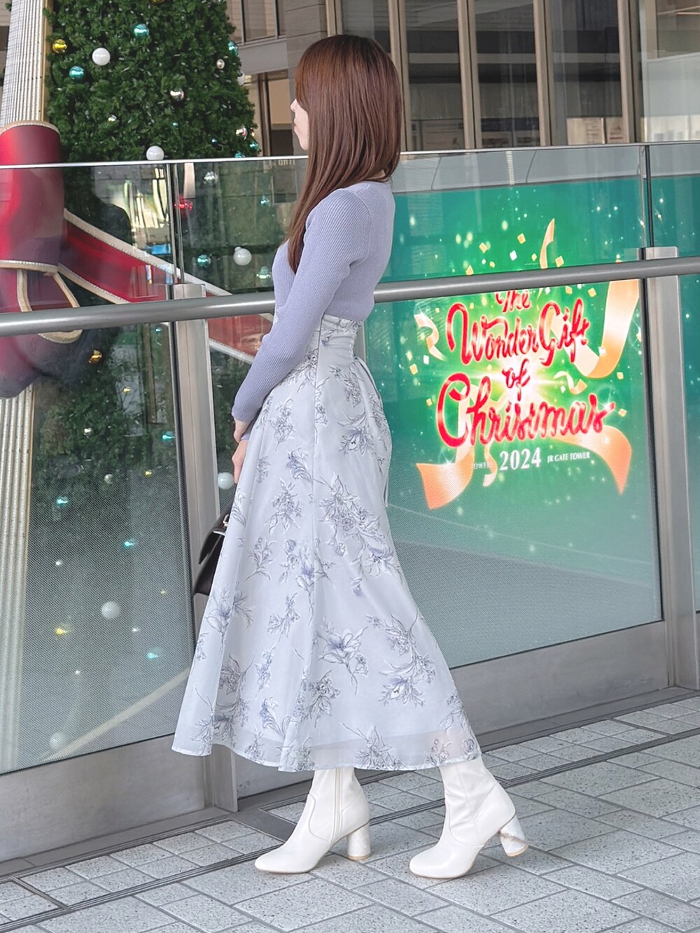 パープル系のワンピース、ホワイト系のブーツ、ブラウン系のハンドバッグを着用したレディースの秋コーディネートの4枚目の写真