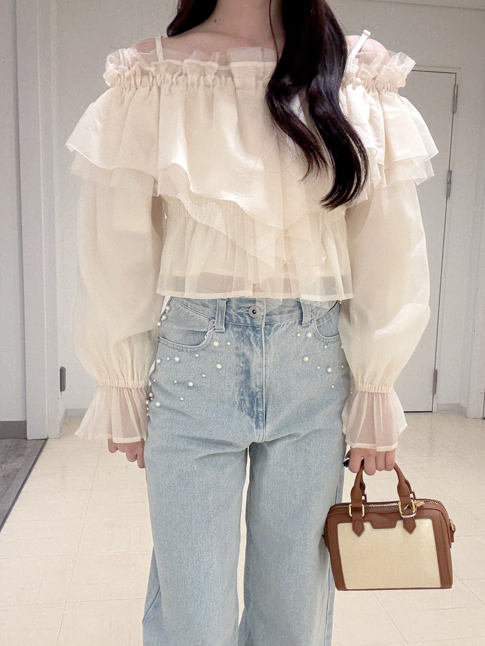 ホワイト系のシャツ/ブラウス、ブルー系のデニムパンツ、ブラウン系のハンドバッグを着用したレディースの春コーディネートの6枚目の写真