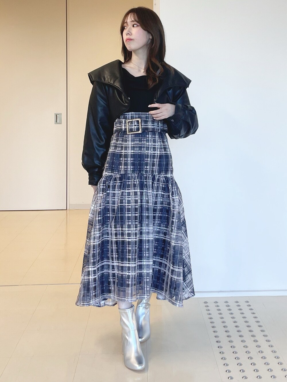 ブルー系のワンピース、シルバー系のブーツ、ブラック系のライダースジャケットを着用したレディースの冬コーディネートの2枚目の写真