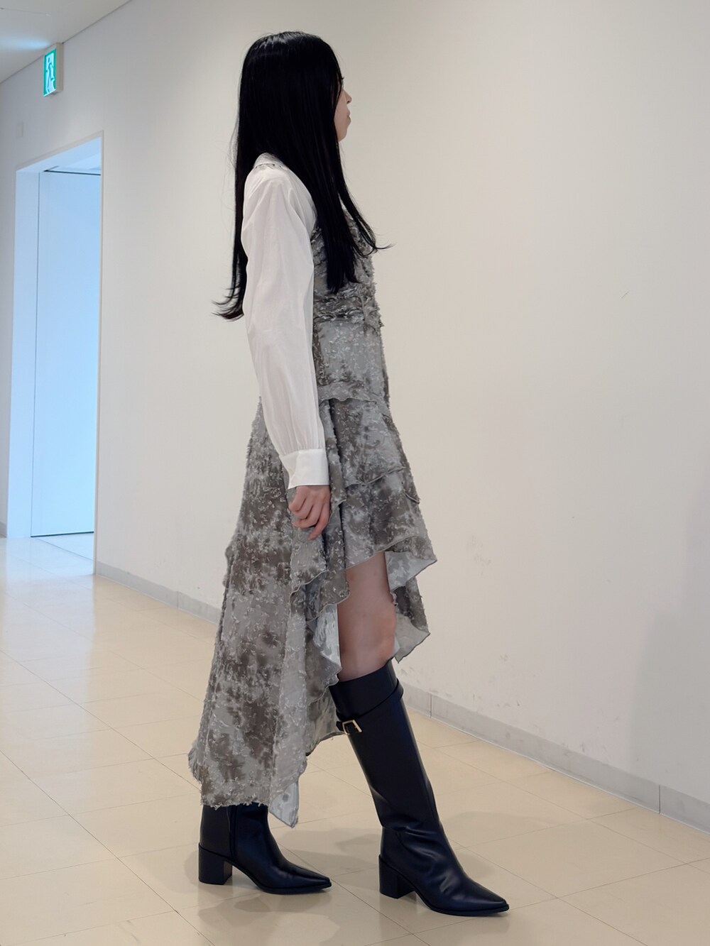 グリーン系のワンピース、ブラック系のハンドバッグ、ブラック系のブーツを着用したレディースの秋コーディネートの5枚目の写真