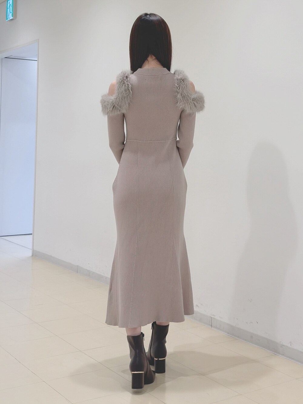 ベージュ系のワンピース、ホワイト系のハンドバッグ、ブラウン系のブーツを着用したレディースの冬コーディネートの7枚目の写真