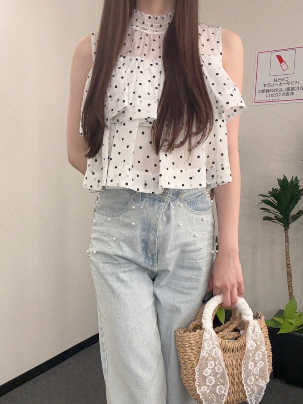 ベージュ系のハンドバッグ、ブラウン系のサンダル、ブルー系のデニムパンツを着用したレディースの夏コーディネートの5枚目の写真