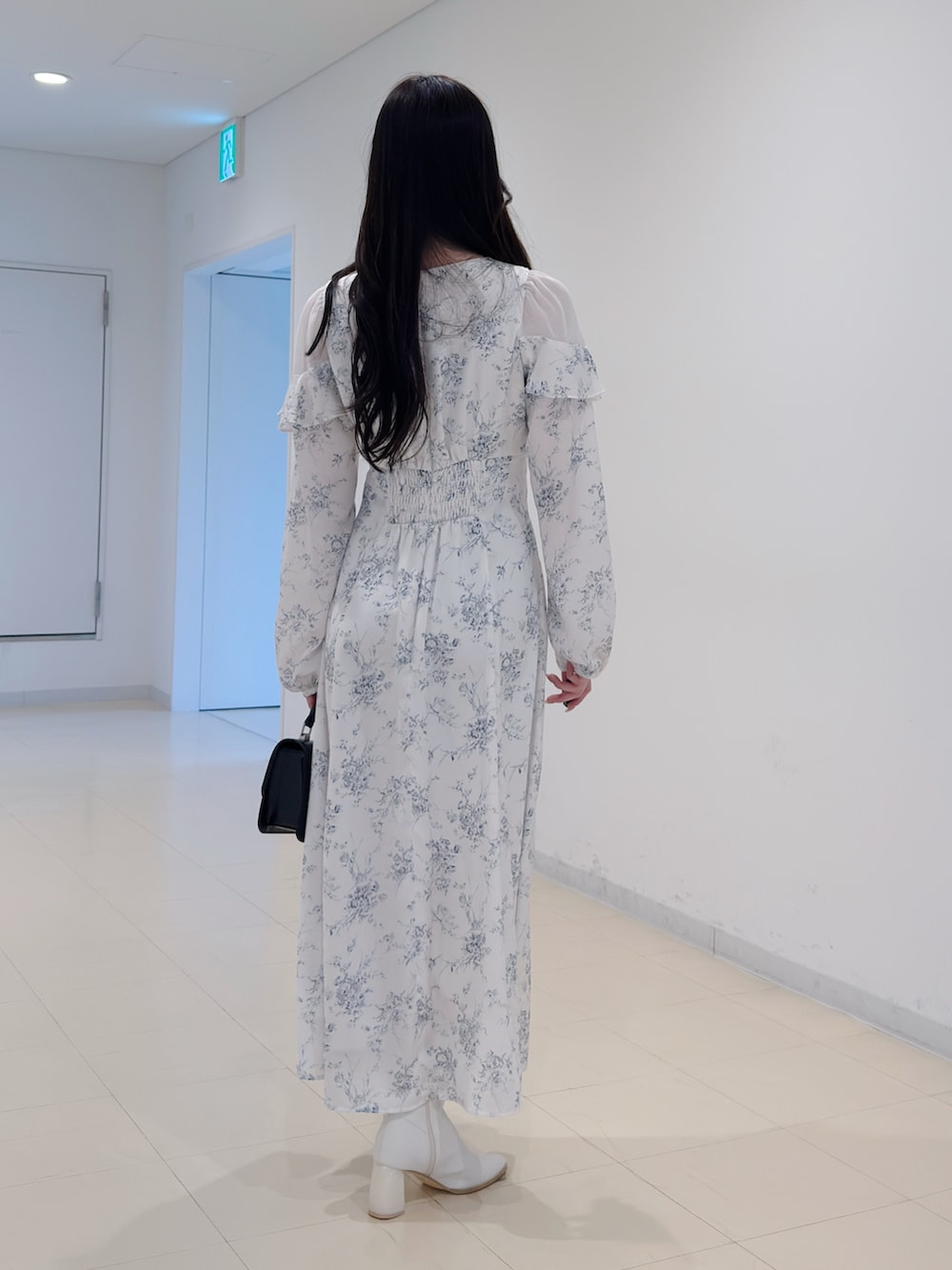 ホワイト系のワンピース、ブラック系のハンドバッグ、ホワイト系のブーツを着用したレディースの冬コーディネートの5枚目の写真