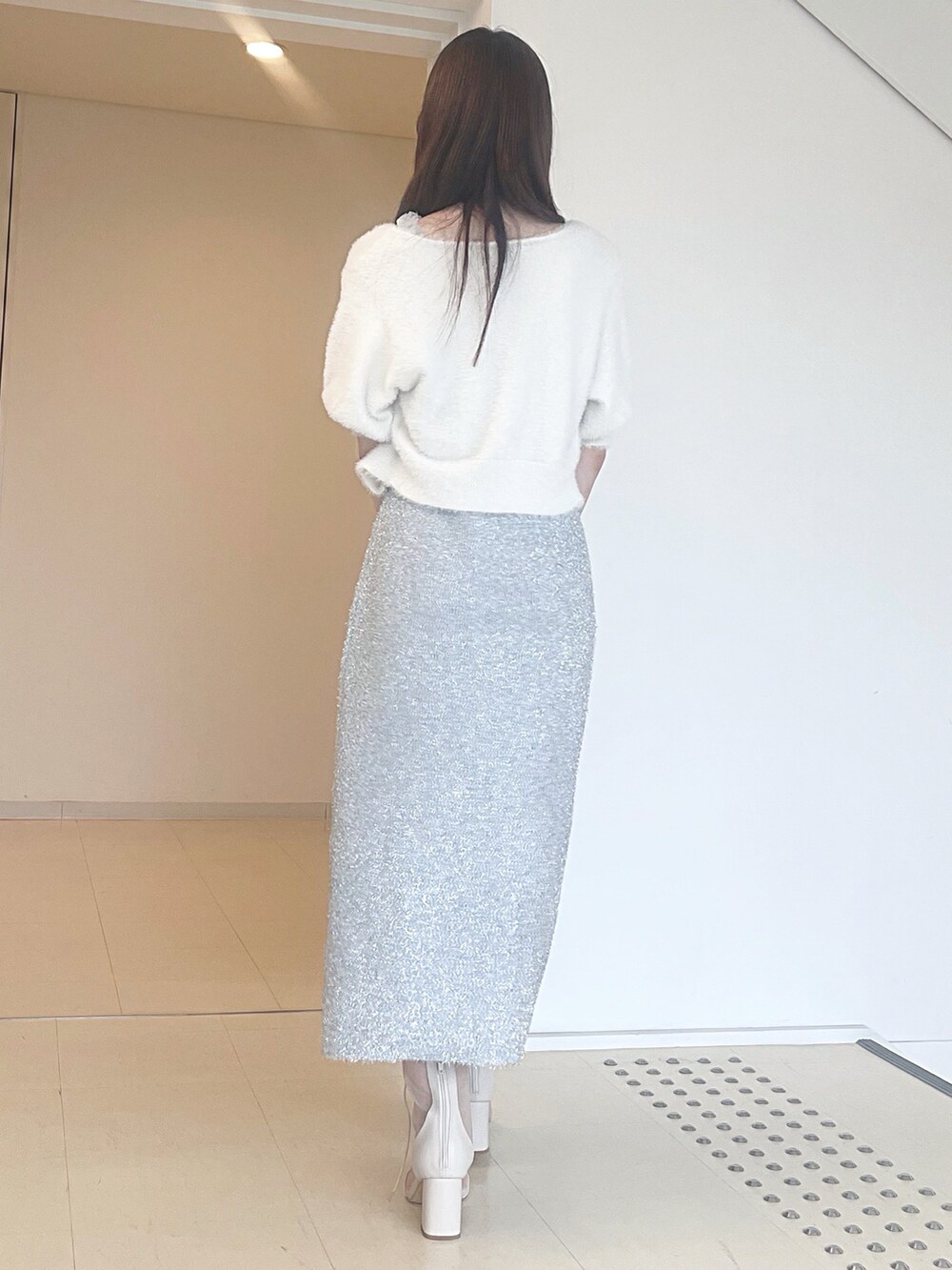 ホワイト系のカーディガン/ボレロ、シルバー系のワンピース、ブラック系のハンドバッグを着用したレディースの秋コーディネートの5枚目の写真