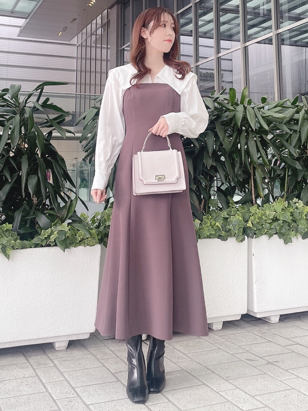 パープル系のワンピース、ブラック系のブーツを着用したレディースの冬コーディネートの2枚目の写真